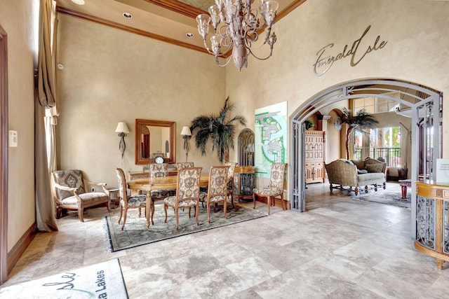 dining area with a high ceiling, crown molding, and an inviting chandelier