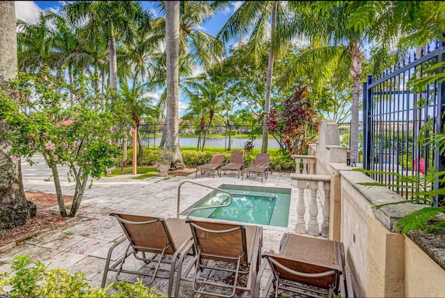 view of swimming pool with a patio and a water view