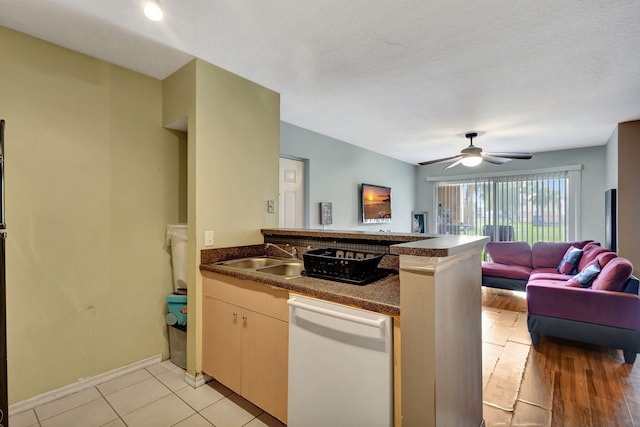 kitchen with kitchen peninsula, ceiling fan, light hardwood / wood-style flooring, dishwasher, and sink