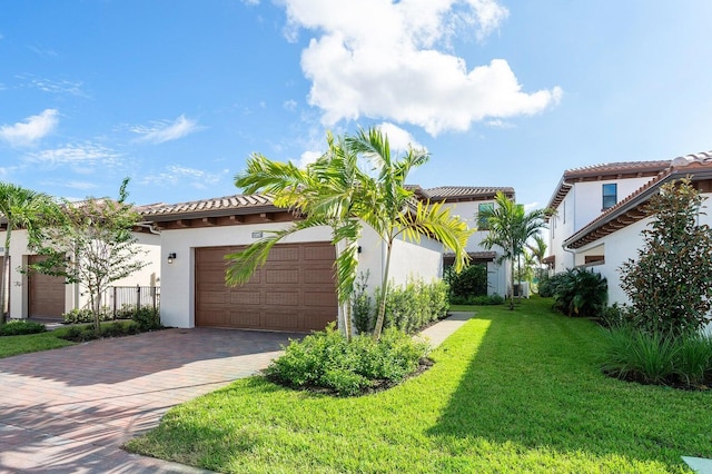 mediterranean / spanish-style home featuring a front yard and a garage