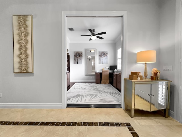 foyer featuring ornamental molding and ceiling fan