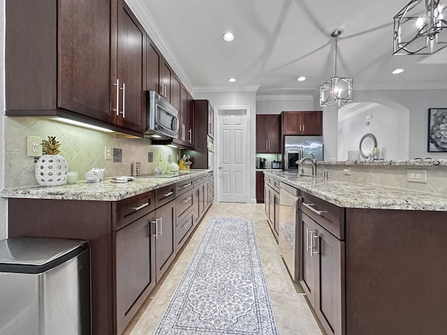 kitchen with tasteful backsplash, appliances with stainless steel finishes, decorative light fixtures, and a chandelier