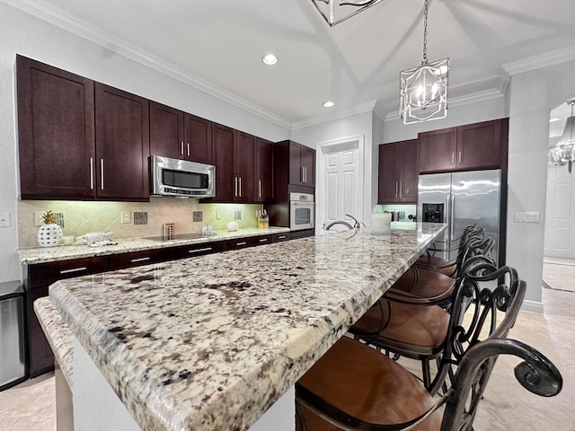 kitchen with a center island with sink, crown molding, hanging light fixtures, and stainless steel appliances