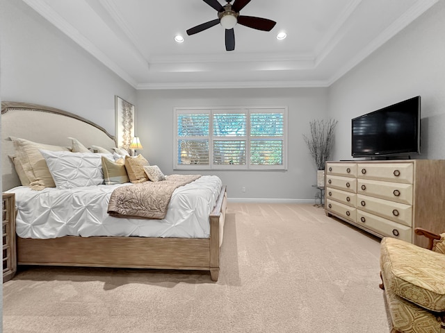 bedroom featuring ceiling fan, ornamental molding, a tray ceiling, and light colored carpet