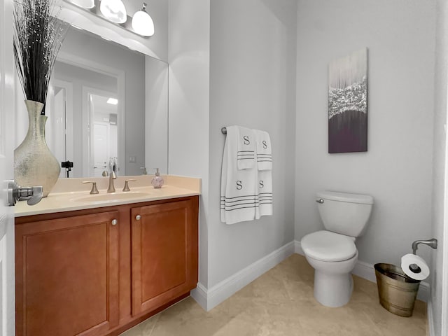 bathroom featuring vanity, toilet, and tile patterned flooring