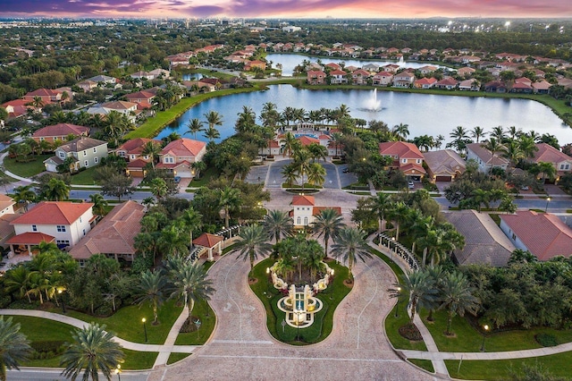 aerial view at dusk featuring a water view