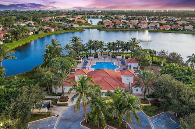 aerial view at dusk featuring a water view