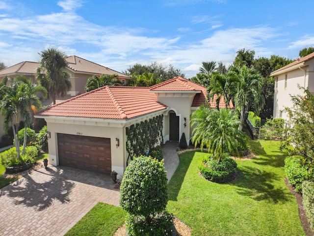 mediterranean / spanish-style home with a front yard and a garage