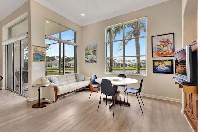 dining room featuring crown molding, light hardwood / wood-style flooring, and plenty of natural light