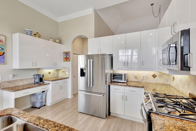 kitchen featuring white cabinets, dark stone countertops, stainless steel appliances, and high vaulted ceiling