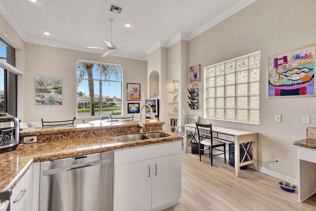 kitchen featuring sink, white cabinetry, stainless steel dishwasher, ornamental molding, and light hardwood / wood-style flooring