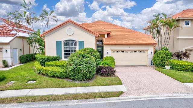 mediterranean / spanish-style house featuring a front yard and a garage