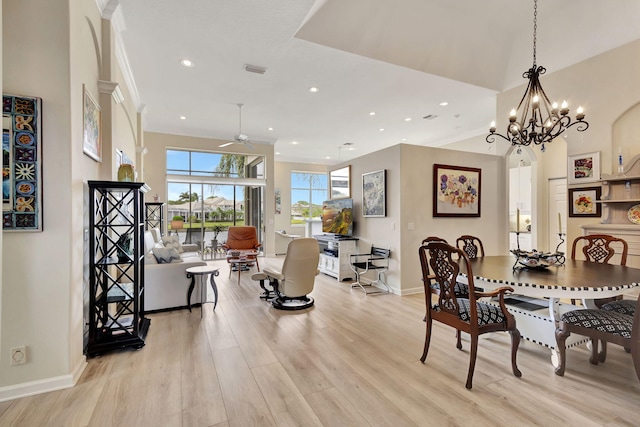 dining room featuring ceiling fan with notable chandelier and light hardwood / wood-style floors