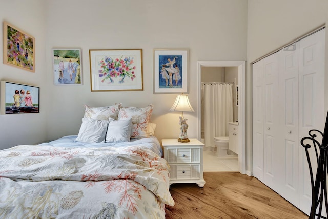 bedroom with a closet, ensuite bathroom, and light wood-type flooring