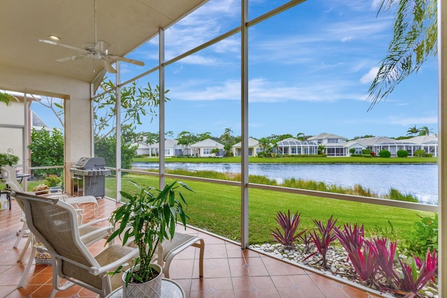 sunroom / solarium featuring a water view and ceiling fan