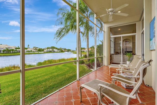 sunroom / solarium with a water view and ceiling fan