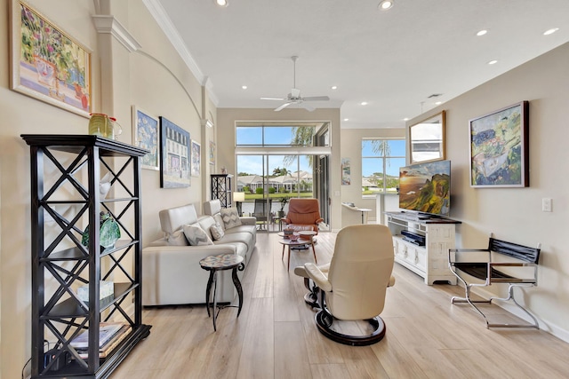 living room with light hardwood / wood-style flooring, ceiling fan, and crown molding