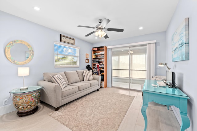 living room with ceiling fan and light hardwood / wood-style flooring