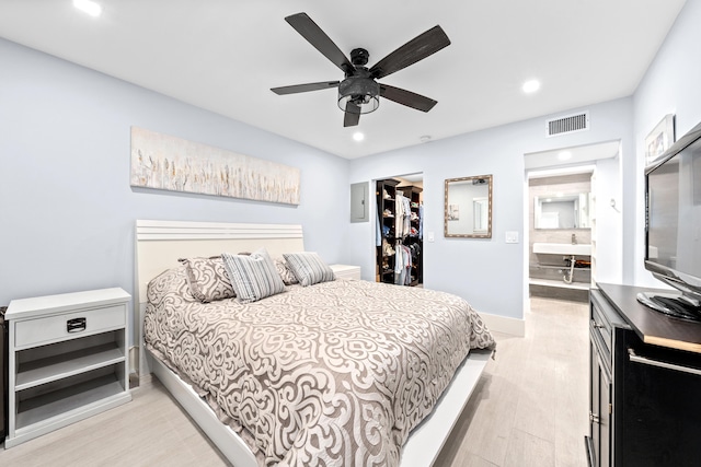 bedroom featuring electric panel, light hardwood / wood-style floors, and ceiling fan