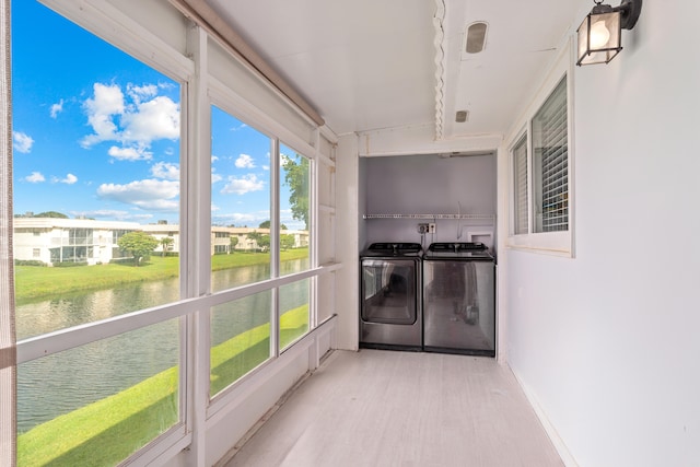 sunroom / solarium with washer and dryer and a water view