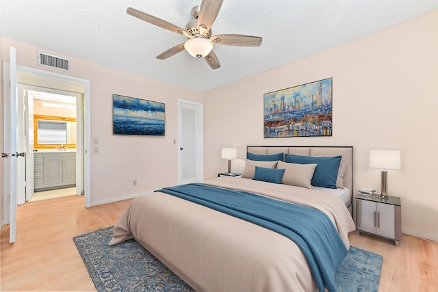 bedroom featuring light hardwood / wood-style flooring, a textured ceiling, a closet, and ceiling fan