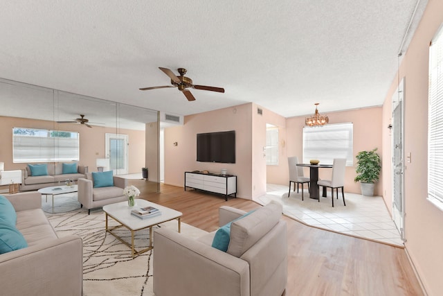 living room with a healthy amount of sunlight, a textured ceiling, and light hardwood / wood-style flooring