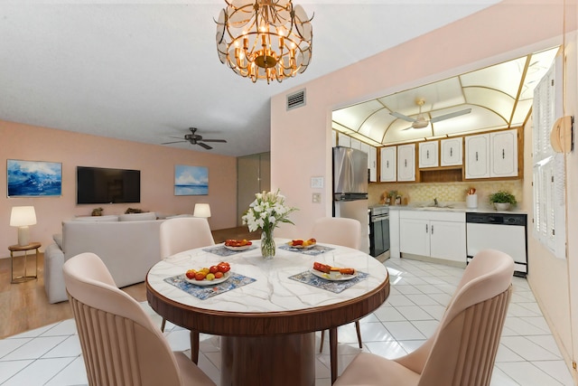 tiled dining space with sink and ceiling fan with notable chandelier