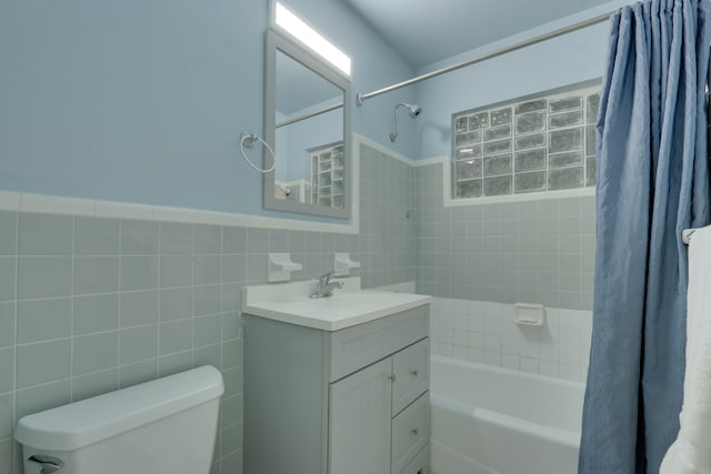 full bathroom with vanity, toilet, shower / bathtub combination with curtain, and tile walls