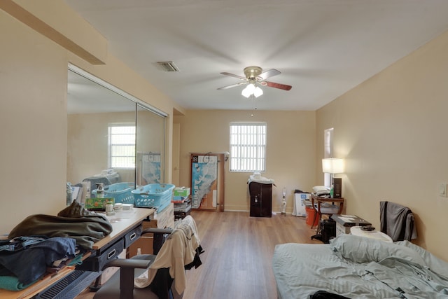 bedroom featuring ceiling fan, light hardwood / wood-style floors, and a closet