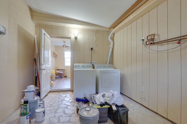 washroom featuring washer and clothes dryer and wooden walls