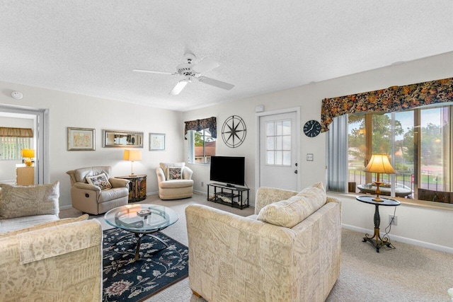 carpeted living room with ceiling fan and a textured ceiling