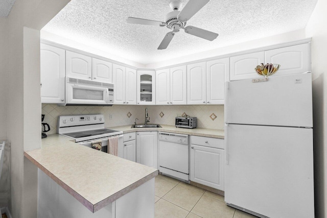 kitchen with backsplash, sink, white cabinets, and white appliances