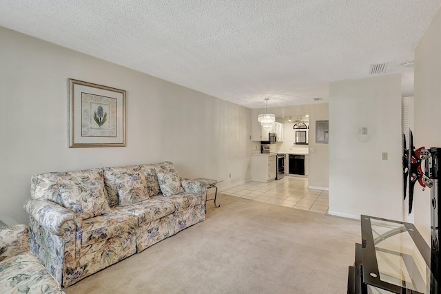 carpeted living room featuring a textured ceiling and a chandelier