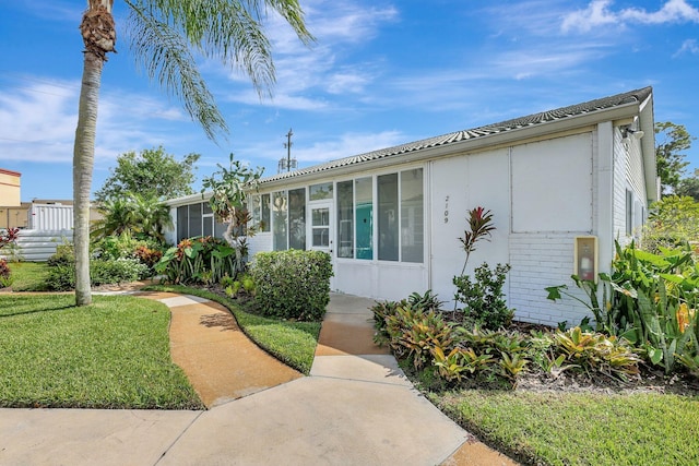 view of front of home featuring a front yard and a sunroom