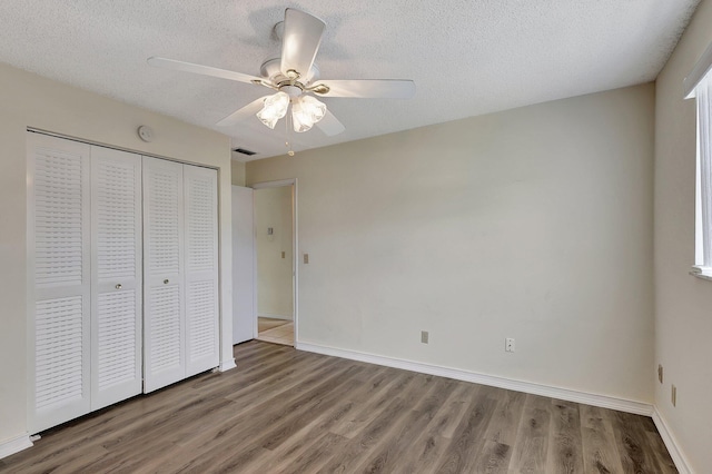 unfurnished bedroom featuring a closet, ceiling fan, a textured ceiling, and hardwood / wood-style floors