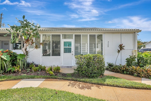 2109 SE Wayne Rd Unit 2109, Stuart, FL 34994 - view of front of house with brick siding and a sunroom