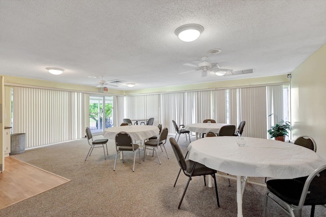 dining space featuring light carpet, a textured ceiling, and ceiling fan