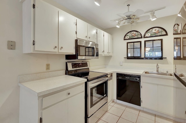 kitchen with stainless steel appliances, sink, light tile patterned floors, white cabinetry, and ceiling fan