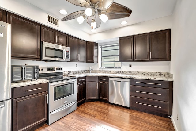 kitchen featuring dark brown cabinets, ceiling fan, appliances with stainless steel finishes, light wood-type flooring, and sink