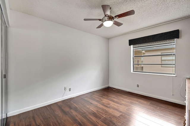 empty room with ceiling fan, a textured ceiling, and dark hardwood / wood-style flooring