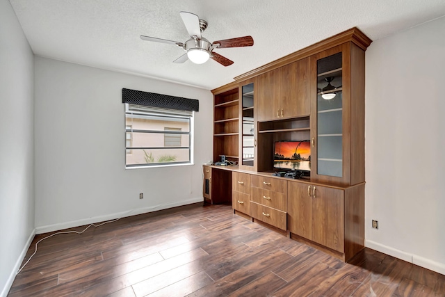 unfurnished office featuring dark wood-type flooring, ceiling fan, and a textured ceiling