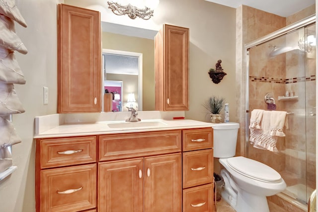 bathroom featuring toilet, an enclosed shower, and vanity