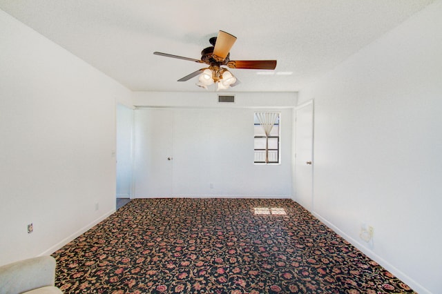 empty room with a textured ceiling, carpet flooring, and ceiling fan