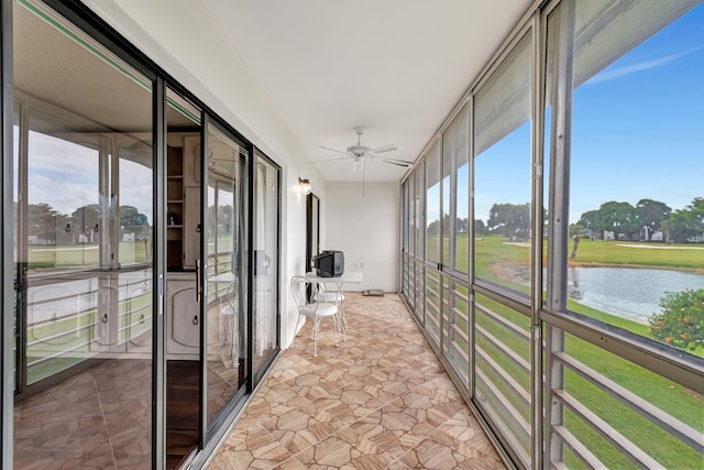 unfurnished sunroom featuring a water view and ceiling fan