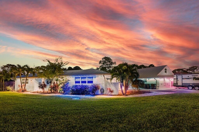 view of front of property with a garage and a lawn