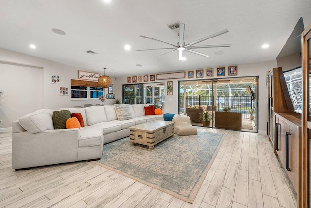 living room featuring light hardwood / wood-style floors and ceiling fan