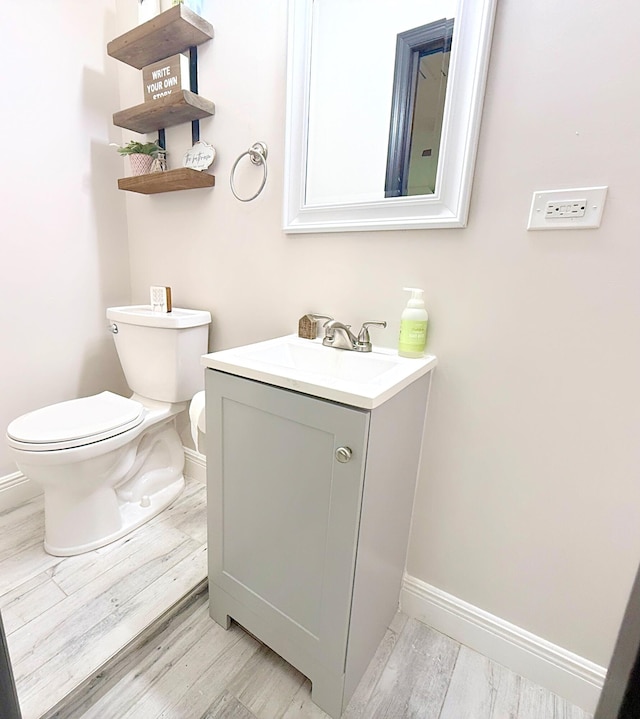 bathroom featuring vanity, hardwood / wood-style flooring, and toilet