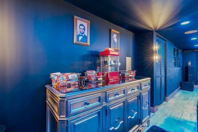 bar with blue cabinetry and light wood-type flooring