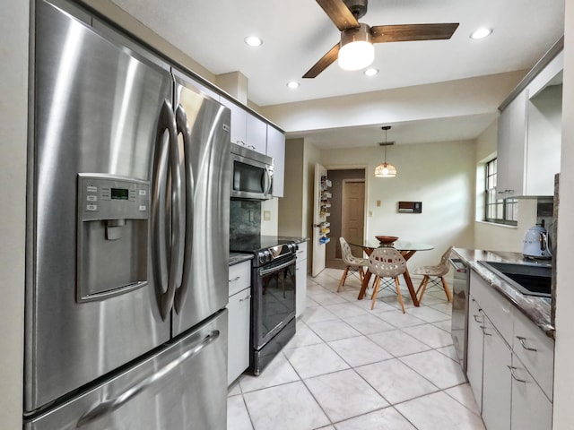 kitchen featuring white cabinetry, ceiling fan, hanging light fixtures, light tile patterned floors, and appliances with stainless steel finishes