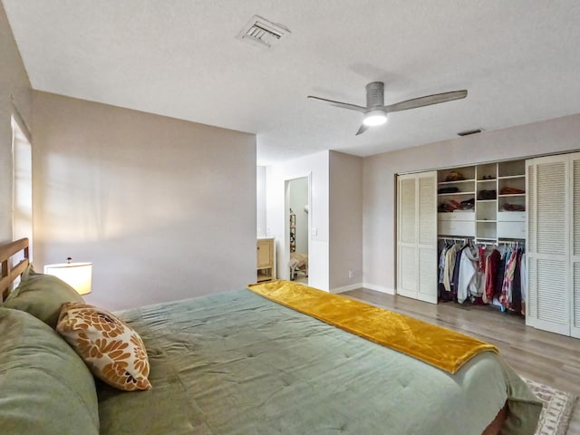 bedroom featuring ceiling fan, hardwood / wood-style floors, and a textured ceiling